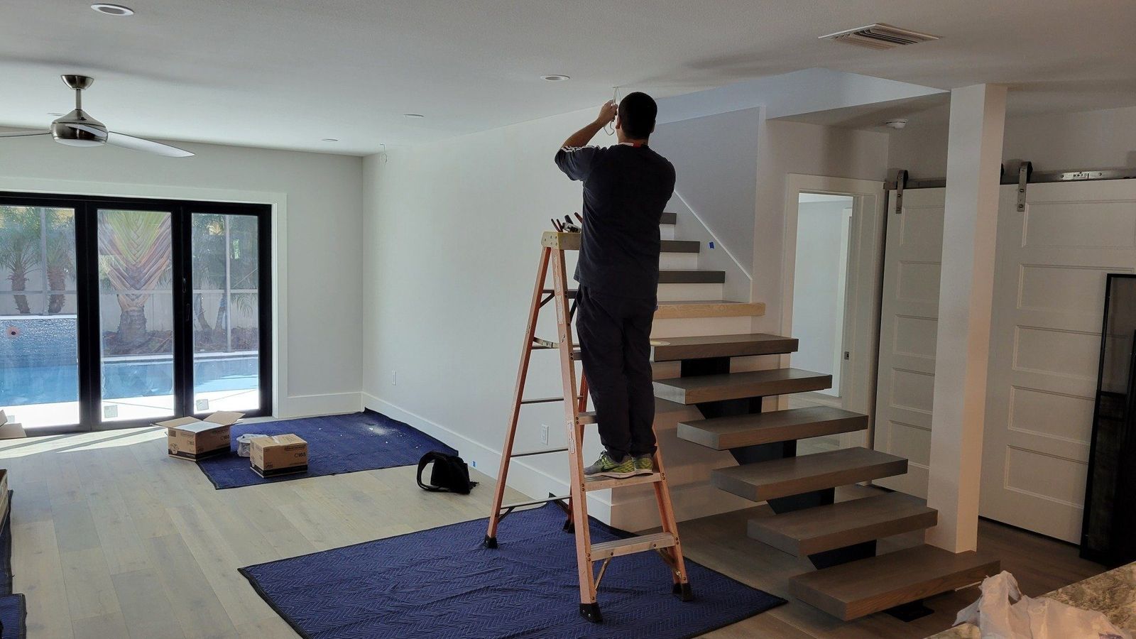 Entertainment Pros installer on ladder during professional TV wall mounting