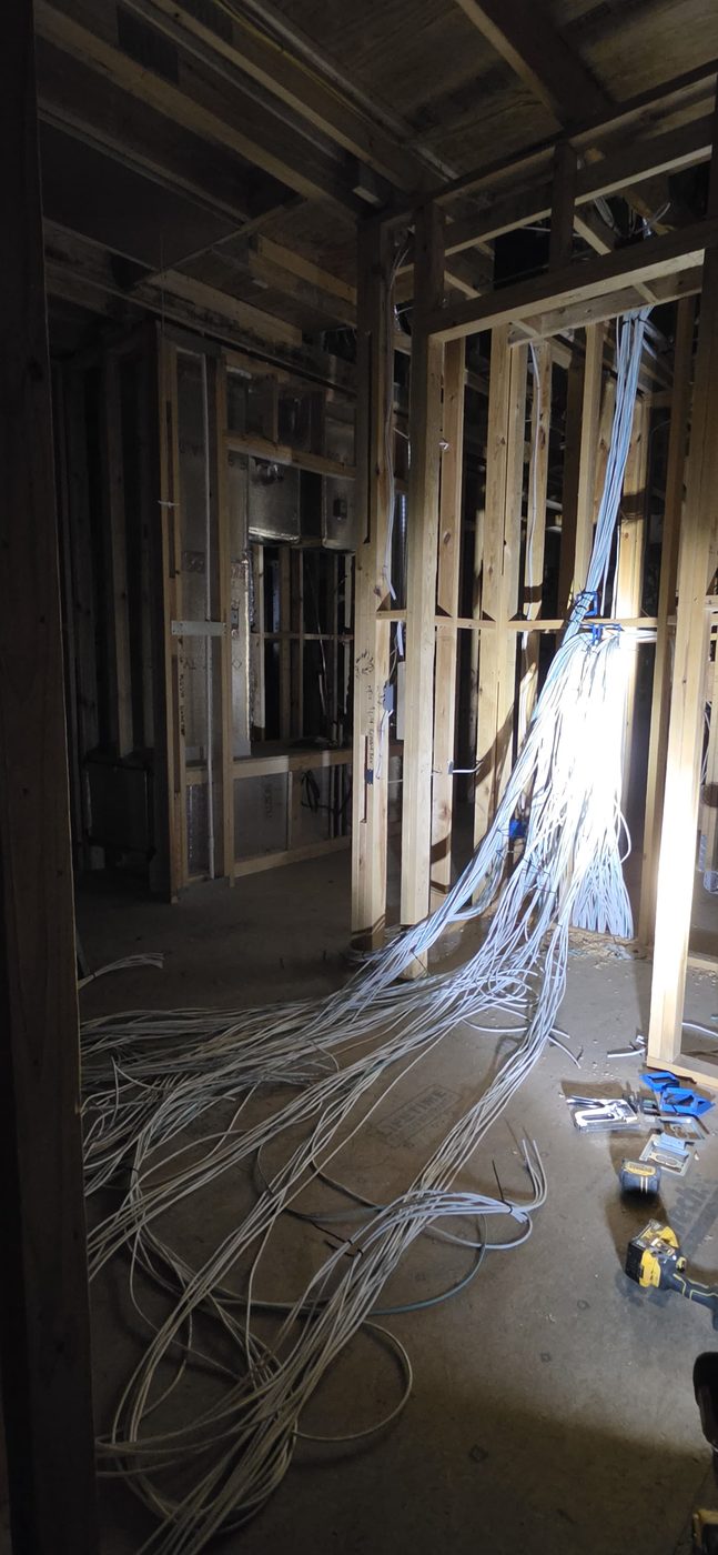 Structured AV wiring neatly run through open wall framing before drywall