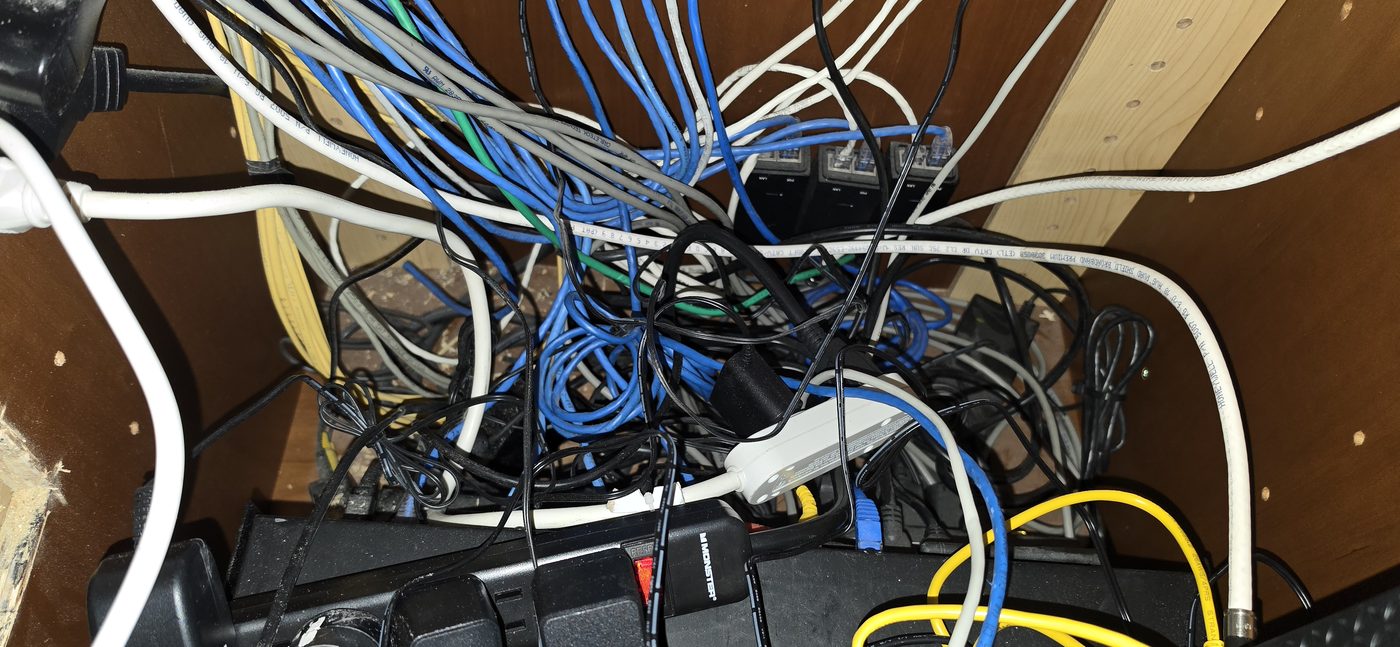 Disconnected and tangled AV cables inside a kitchen-island equipment cabinet