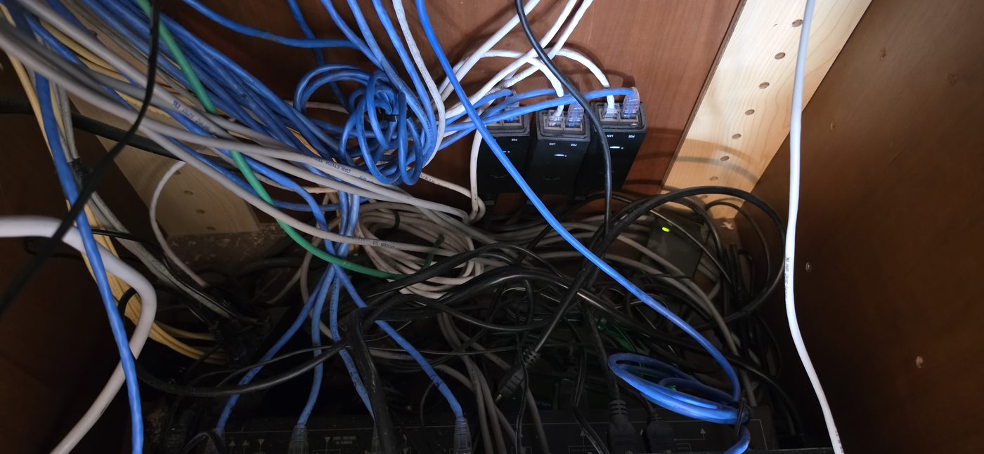 Unlabeled wiring packed behind AV components with no rear access