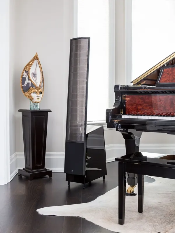 MartinLogan ElectroMotion electrostatic speaker beside a grand piano