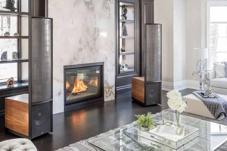 A pair of MartinLogan electrostatic speakers flanking a fireplace in a living room
