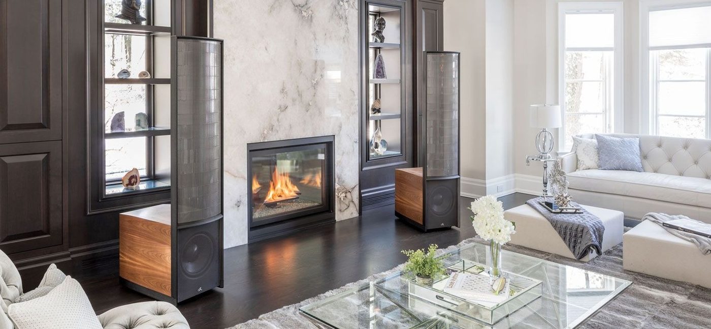 A pair of MartinLogan electrostatic speakers flanking a fireplace in a living room