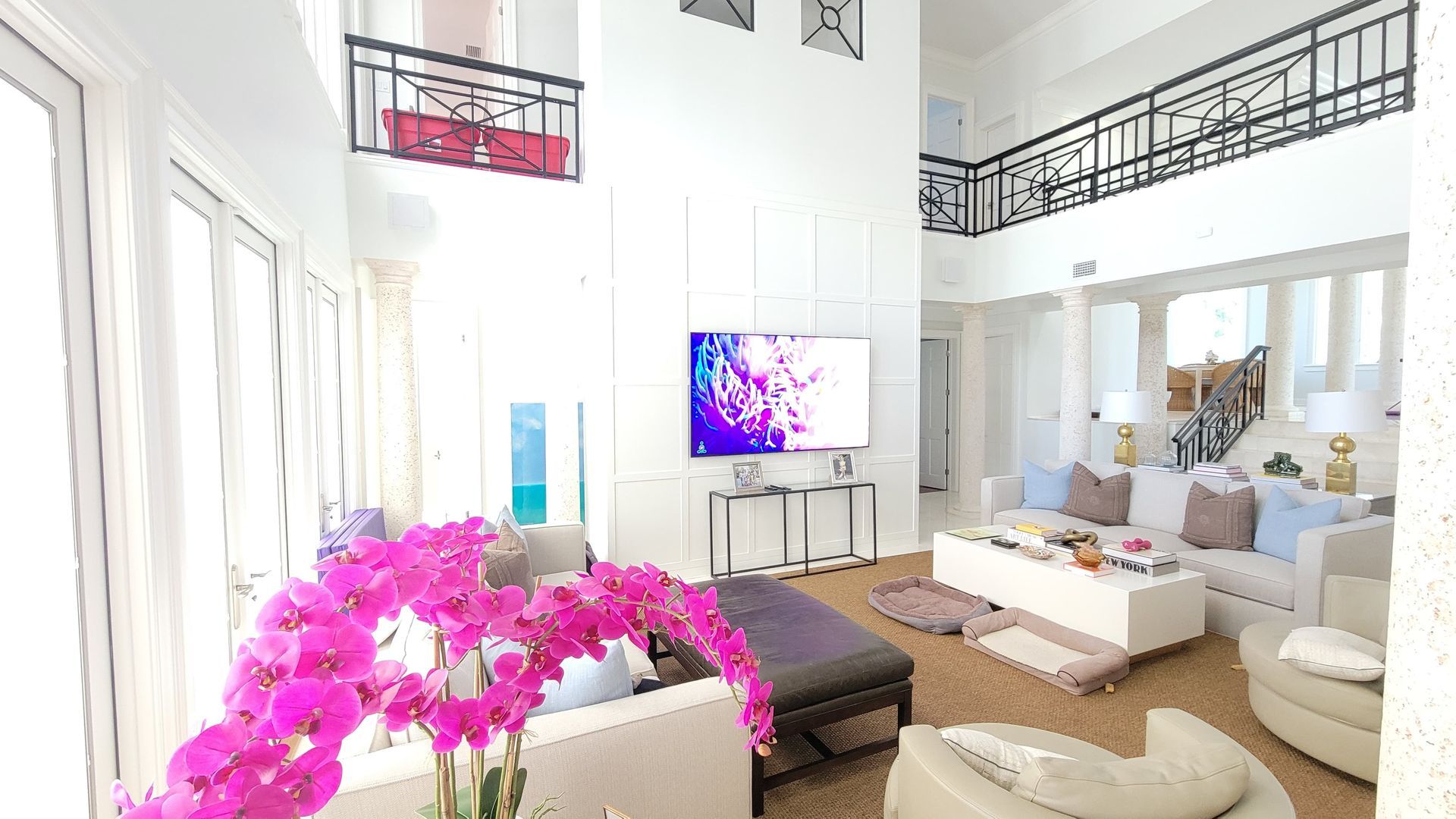 Two-story luxury living room with large wall-mounted TV