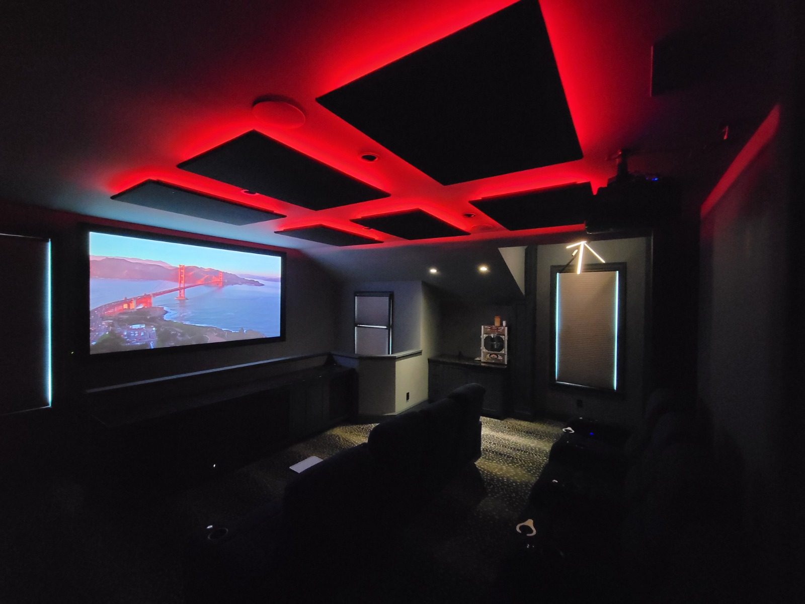 Home theater with red LED ceiling lighting and projection screen
