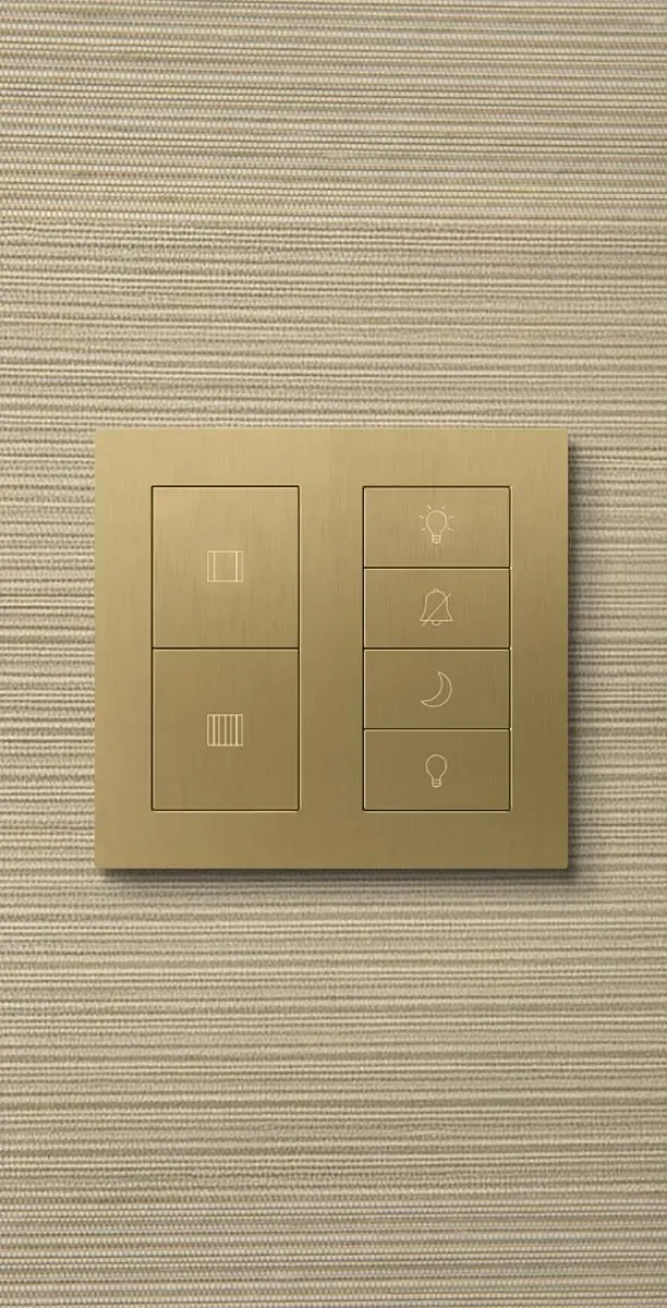 Lutron Palladiom keypad in brushed brass mounted on a woven wallcovering