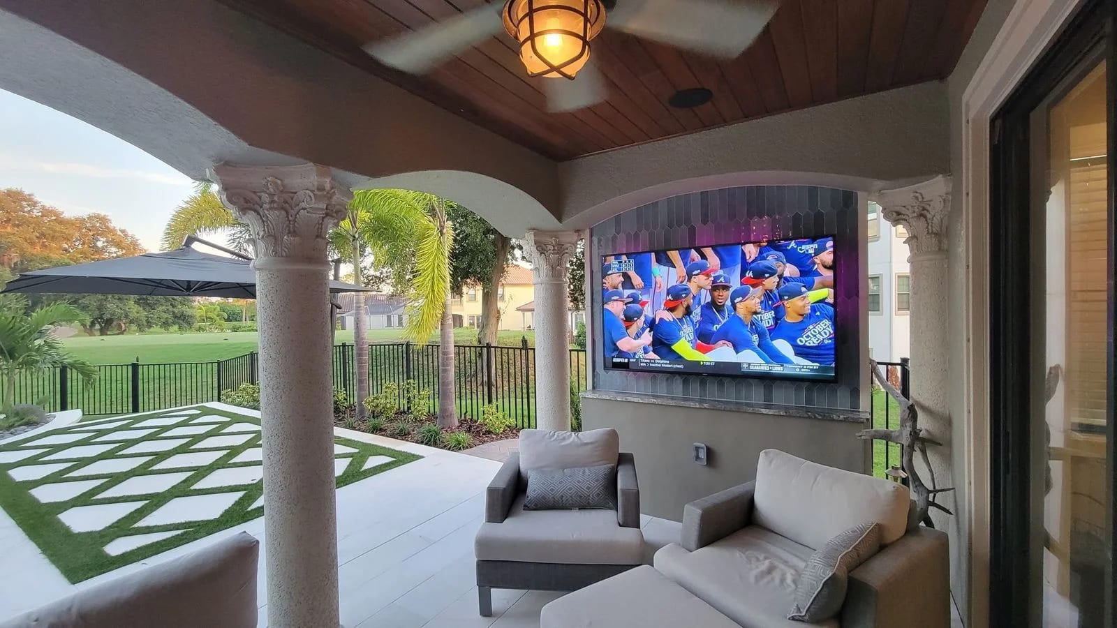 Outdoor TV mounted in a waterfront tiki hut overlooking a dock in Pinellas County