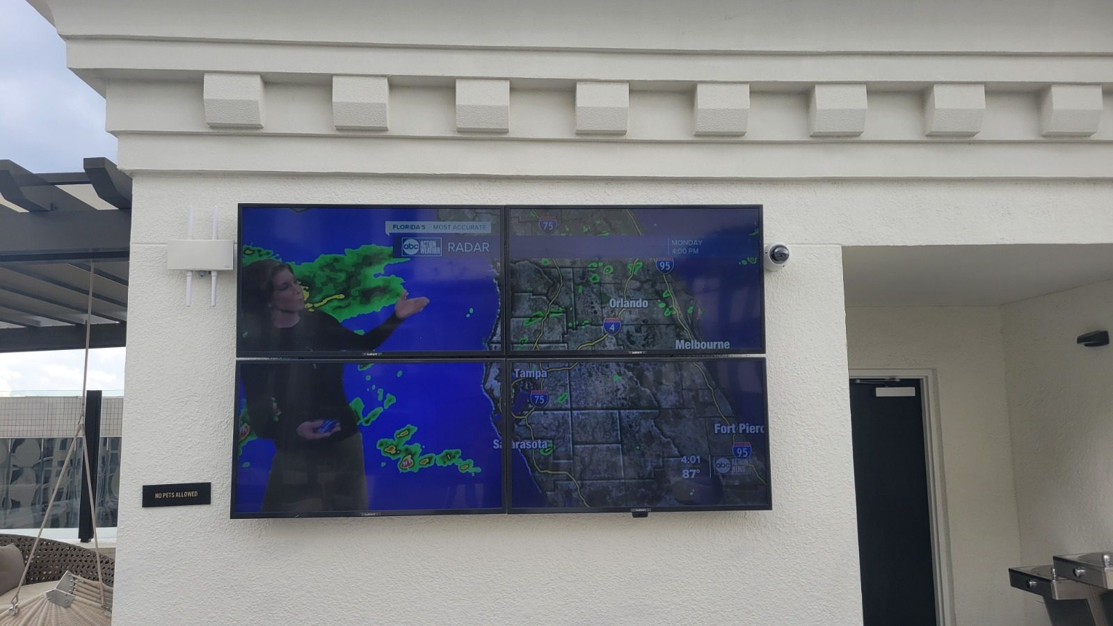 Outdoor TV mounted under a pergola getting partial afternoon sun