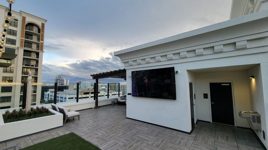 Rooftop outdoor TV against the downtown skyline at dusk