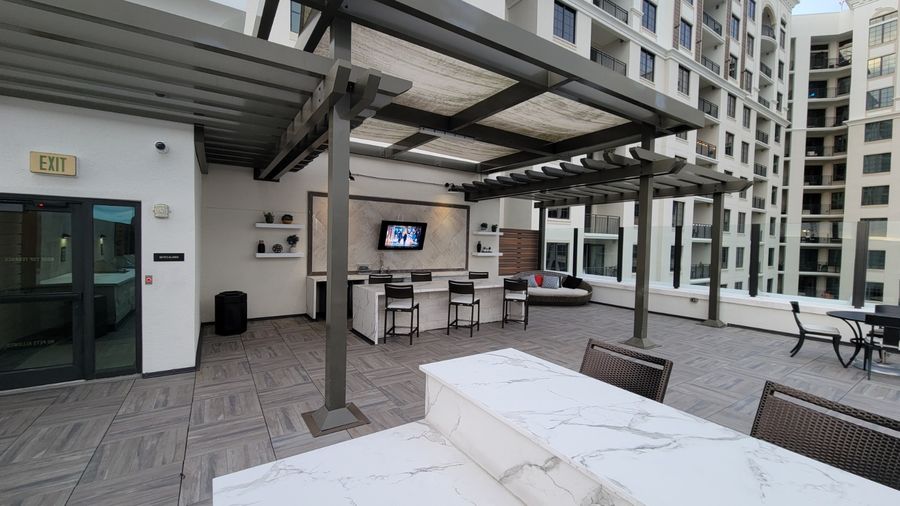 Rooftop lounge with bar seating and a wall mounted TV